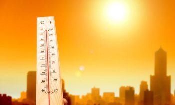 heat wave in the city and hand showing thermometer for high temperature